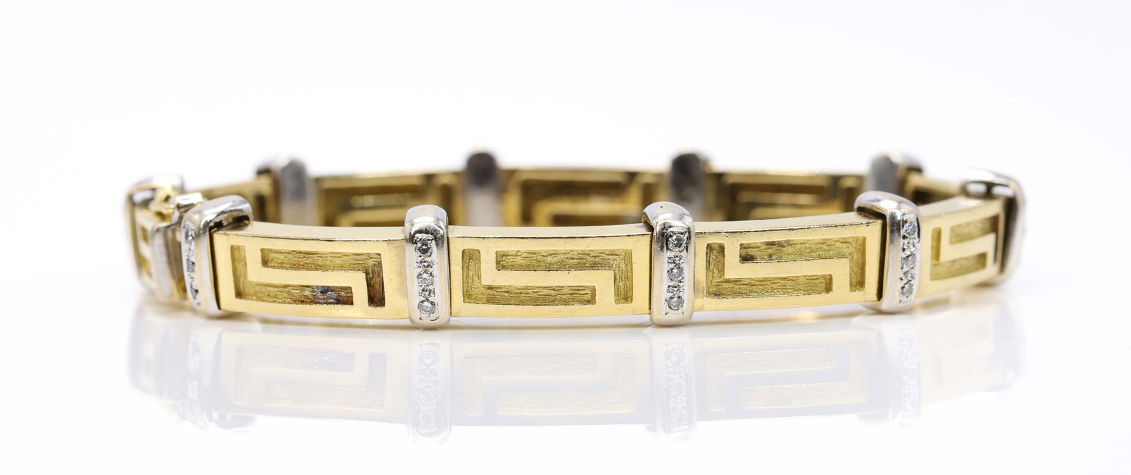 14k YG Diamond Bracelet: 14k two tone gold Greek key bracelet set with thirty round brilliant cut diamonds totaling approximately .45 carat, I color, SI clarity, 6.5mm wide, 7" and 26.1dwt.