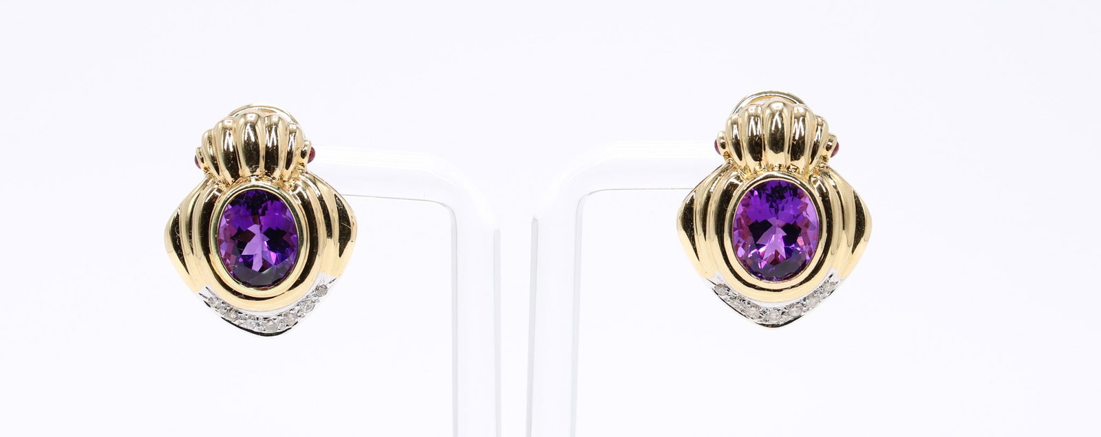 14k YG Amethyst Diamond Earrings: 14k yellow gold earrings set with two oval amethysts measuring approximately 10mm, four small cabochon rubies, and fourteen round brilliant diamonds totaling approximately .21 carat, I color, I2