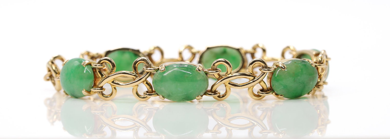 14k YG Jade Bracelet: 14k yellow gold bracelet set with oval jade cabochons measuring approximately 14mm, 7.5", 14.8dwt.