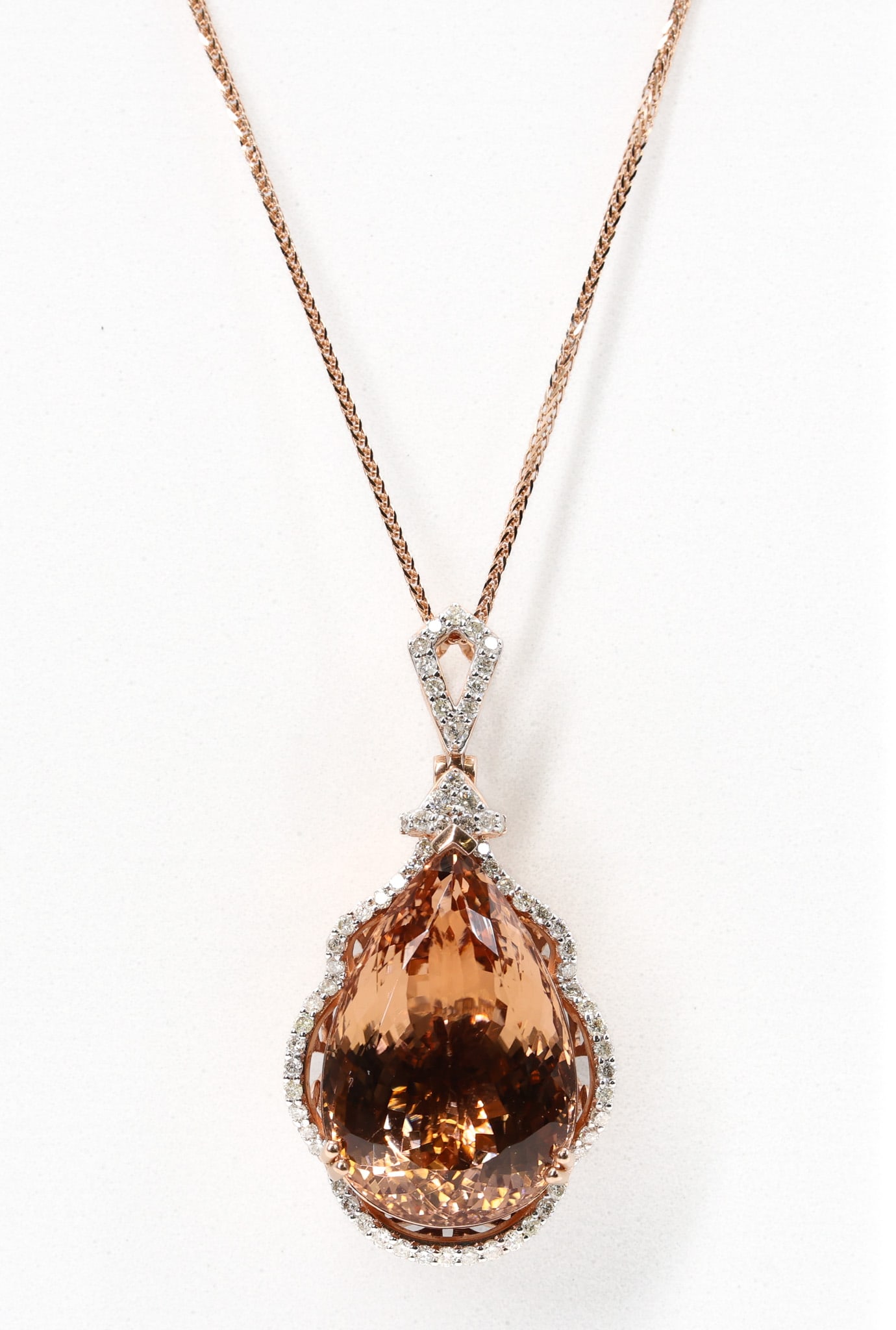Oscar Friedman 14k YG Morganite Necklace: 14k rose gold pendant necklace marked Oscar Friedman set with a pear modified brilliant cut morganite weighing 23.16 carats, brownish orange in color, accented by (66) round brilliant cut diamonds
