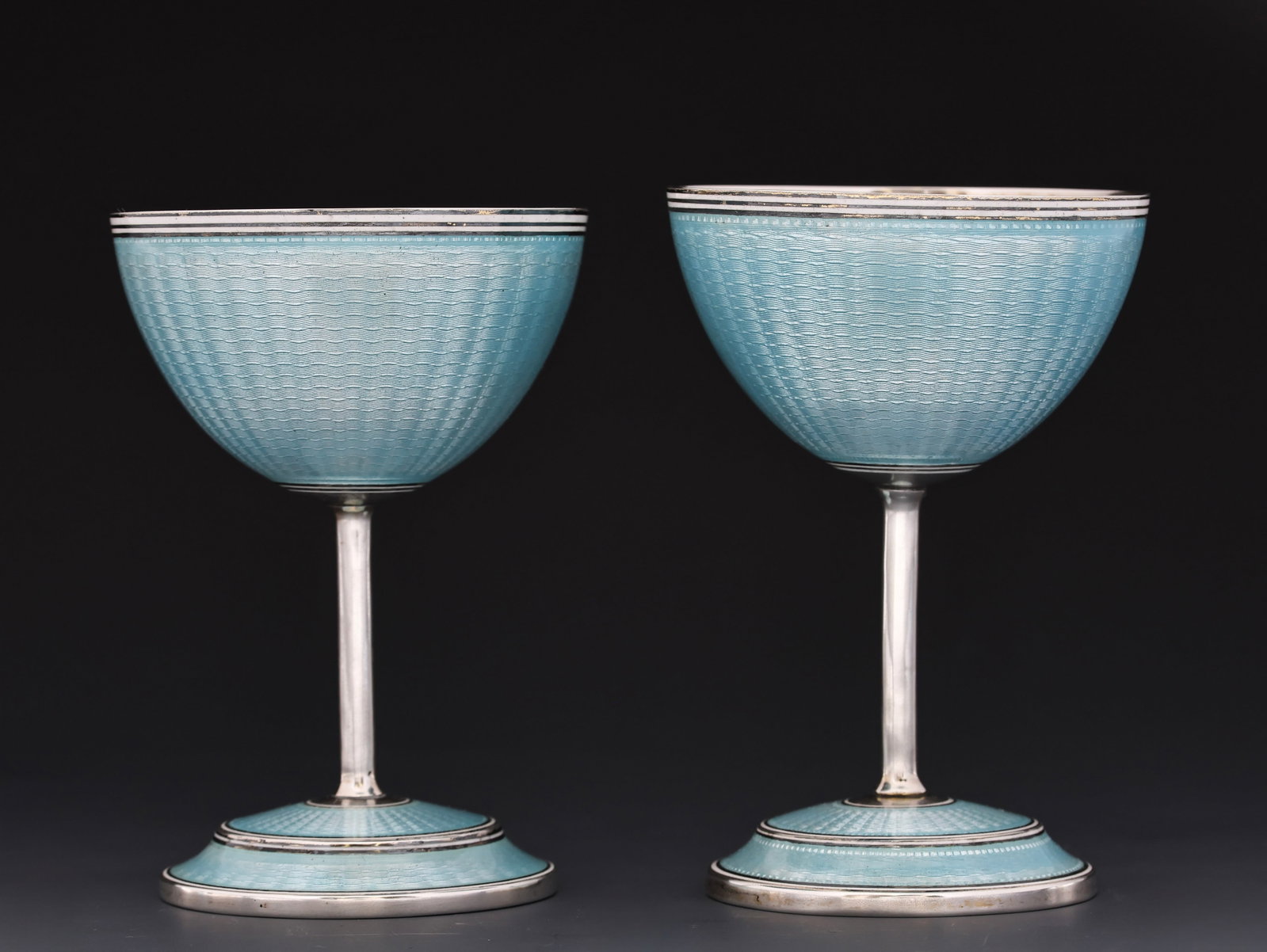 The Thomae Co. Enameled Sterling Silver Champagne Coupes: American sterling silver pair of champagne coupes decorated with baby blue guilloche enameling and gold wash. (2) pieces. 4"h. 8.15 ozt