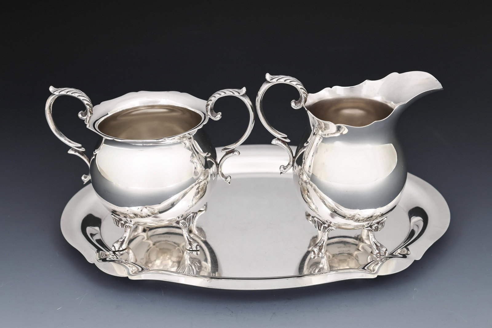 Durham Sterling Silver Teawares: American sterling silver wares, including a creamer, an open sugar bowl, and a tray, all scalloped, the creamer and sugar raised on paw feet and with acanthus accents to the handles. C. 1950's -