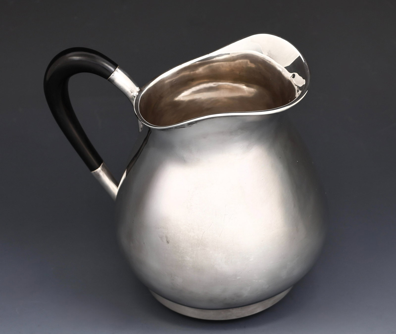E. Dragsted Sterling Silver Pitcher: Danish Modern sterling silver pitcher with an ebonized wood handle. 6.5"h x 7.5"w. 20.77 ozt