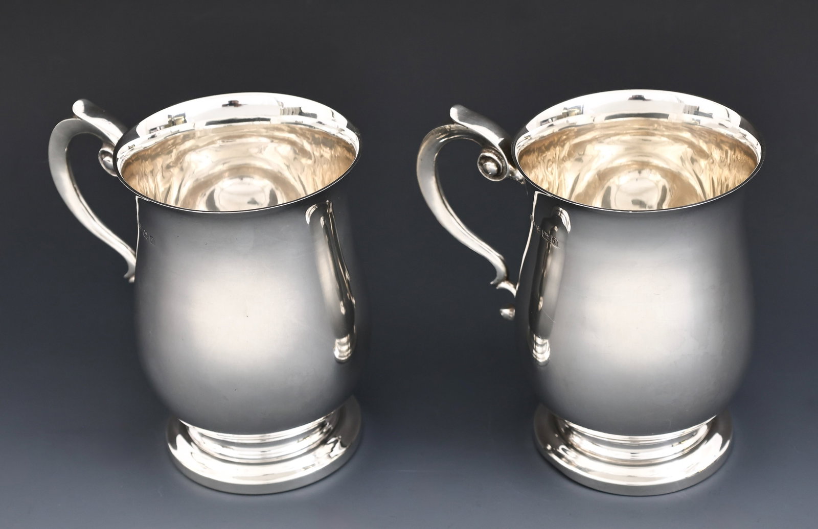 A.E. Posten British Sterling Silver Tankards: Interwar British sterling silver pair of tankards with scroll handles. Birmingham, 1933, by A.E. Poston & Co. Ltd. (2) pieces. 5"h x 5.25"w. 21.77 ozt