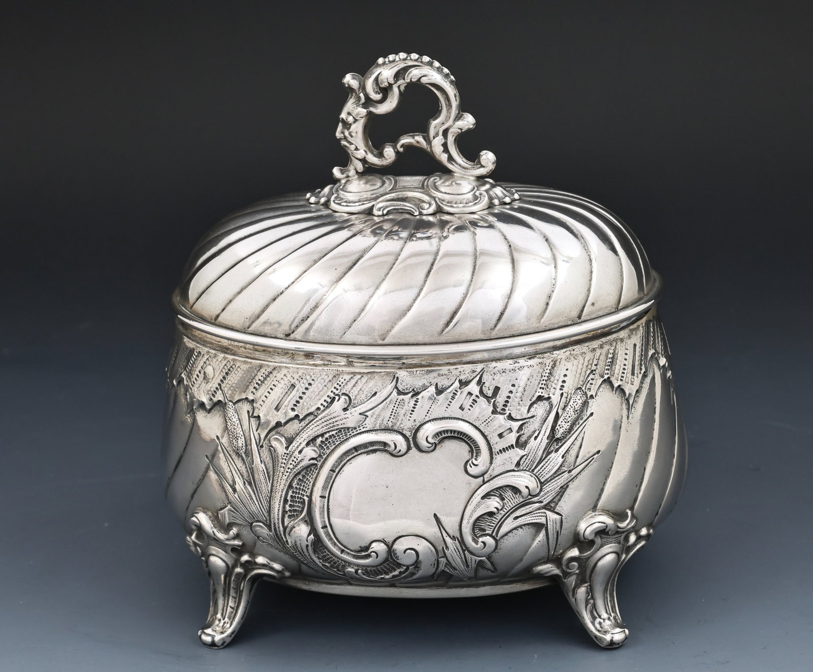 H. Meyen German 800 Silver Etrog Box: German 800 silver Judaica, a gadrooned oval etrog box with chased foliate and volute decoration, an applied finial in the form of a blossom fronted by a grotesque mask and surrounded by volutes and