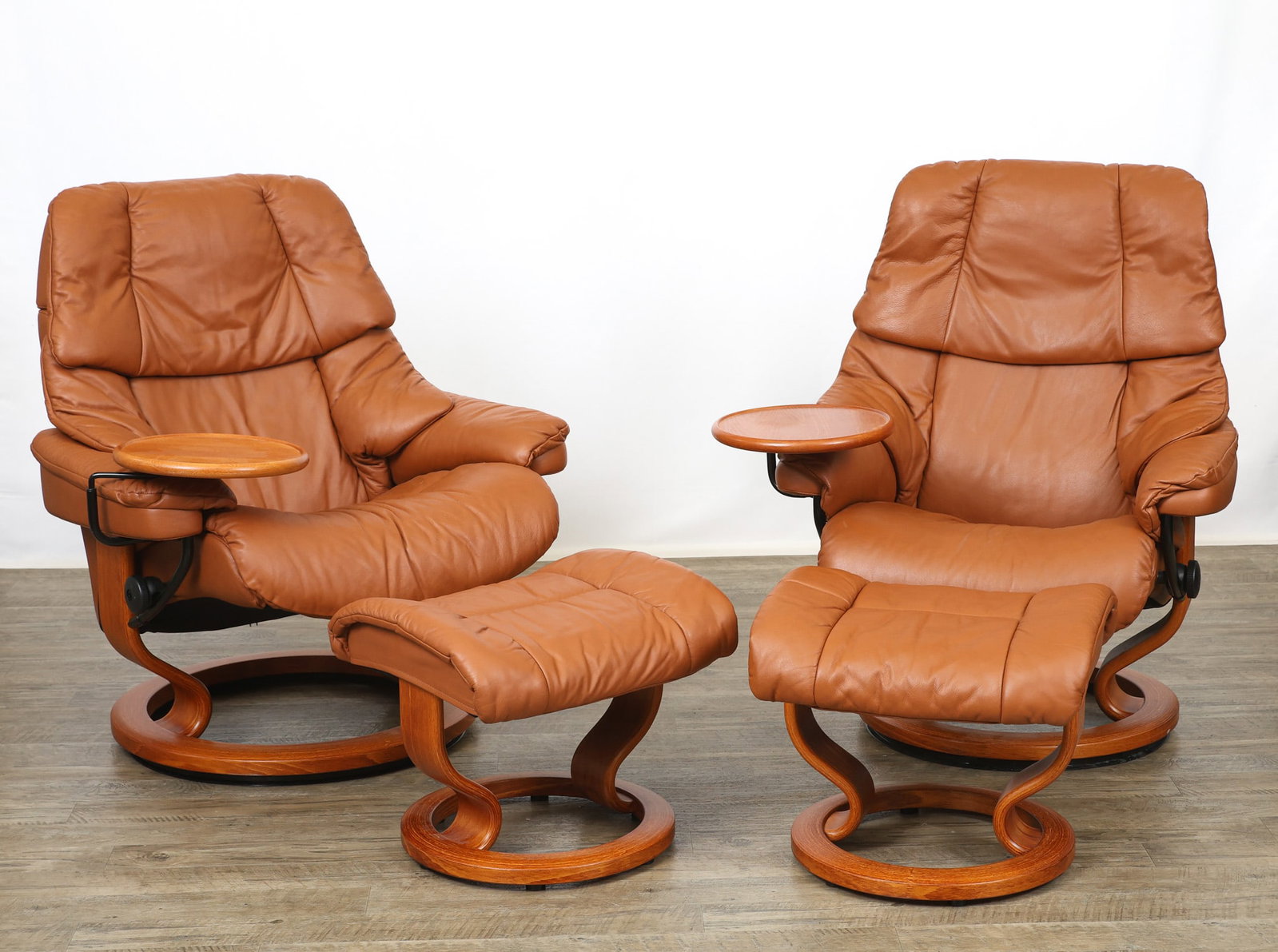 Ekornes "Stressless - Reno" Reclining Chairs and Ottomans: Norwegian Modern complementing pair of reclining swivel lounge chairs and matching ottomans with "Classic" teak finished bases and chocolate leather upholstery. Each chair is fitted with a removable s