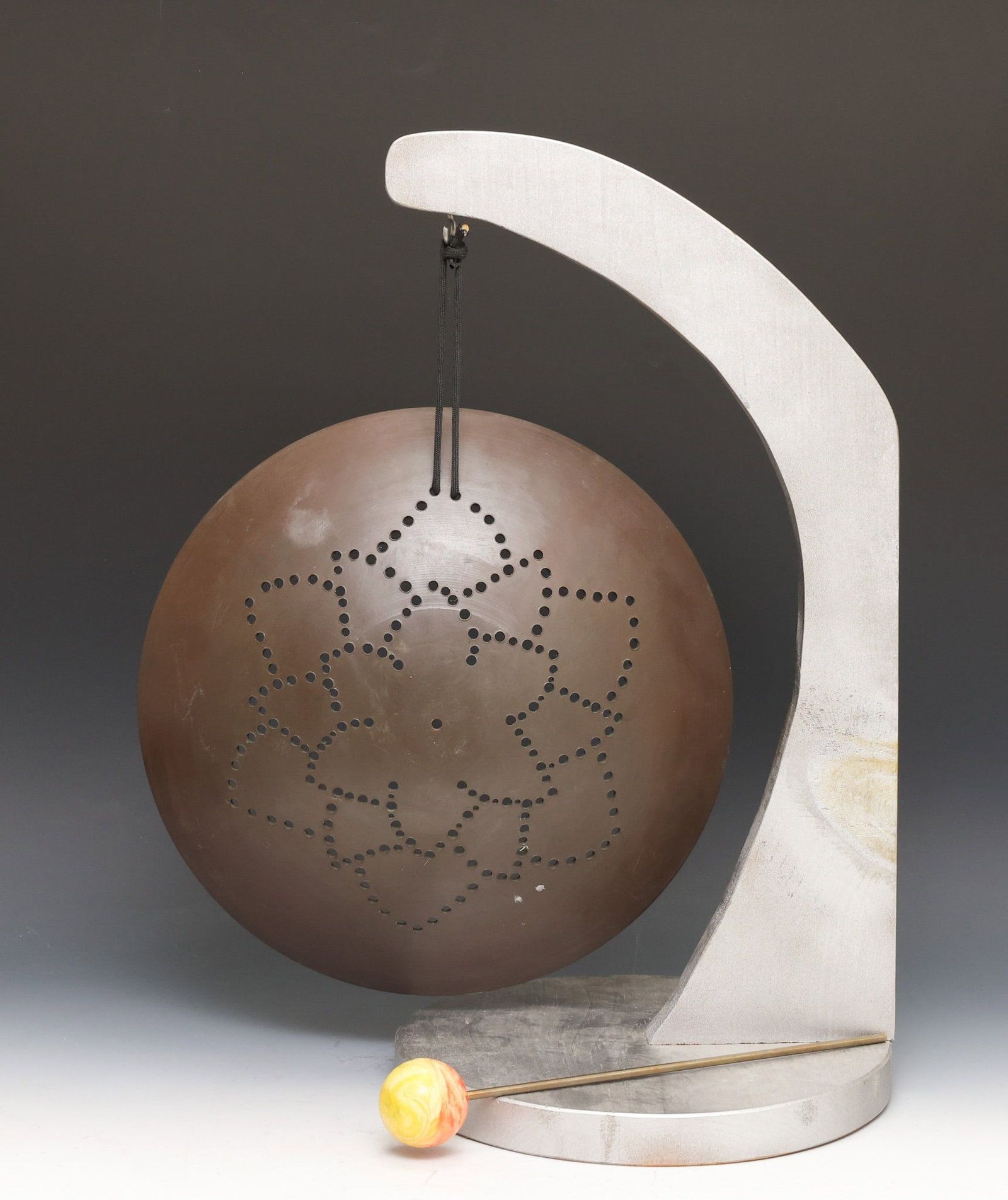 Val Bertoia (B. 1949): "B-1452 Sunflower Gong", bronze with a pierced floral motif, on a silver painted wooden base with a mixed media mallet. The base hand signed for Bertoia Studios. Gong 13.25"w, stand 21.25"h x 11"w
