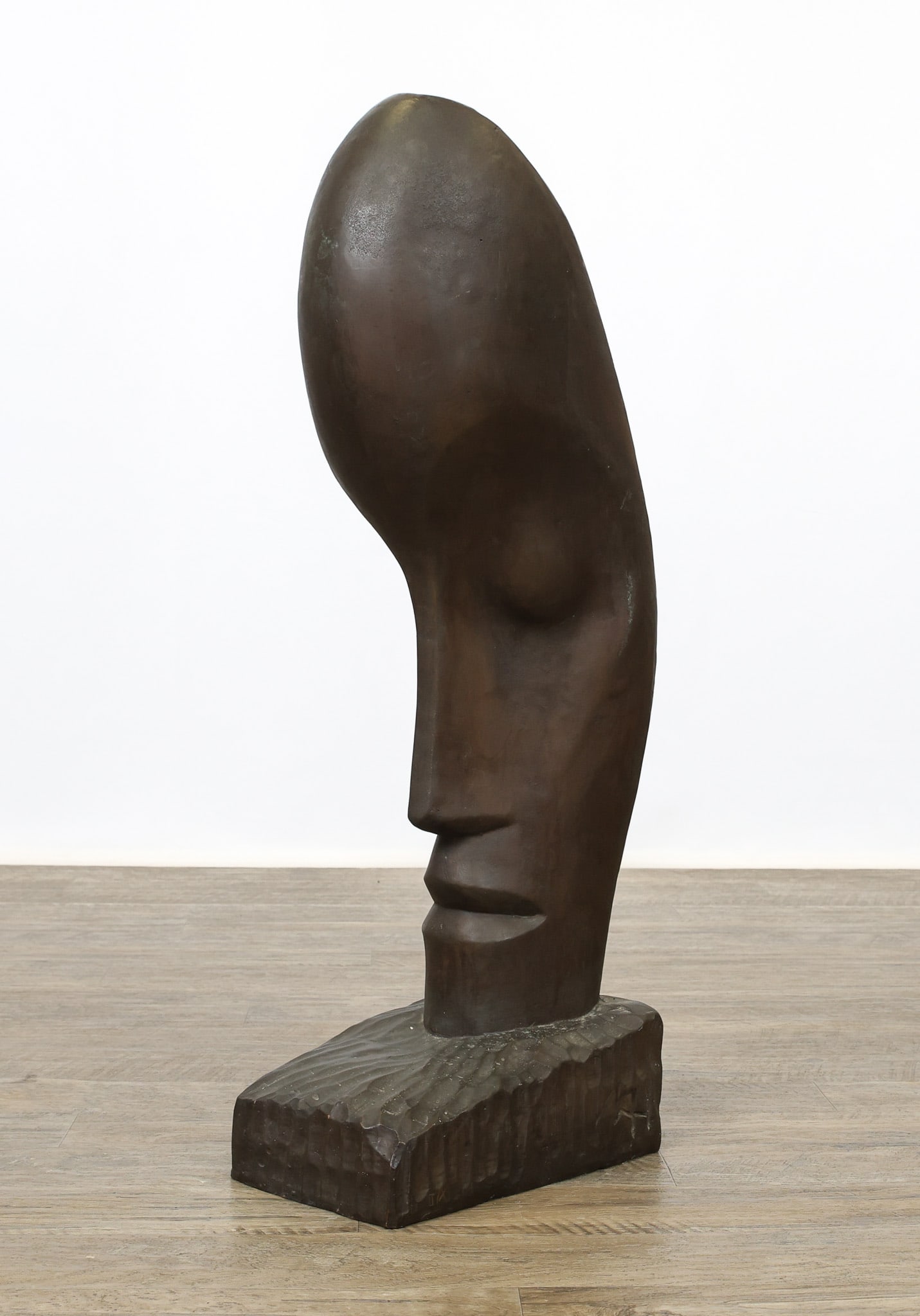 Figural Expressionist Sculpture: Bronze sculpture, "Oktober 1973", a figural expressionist head emerging from a hammered base, with impressed artist's initials "MAH". 30"h x 6.5"w x 11"d