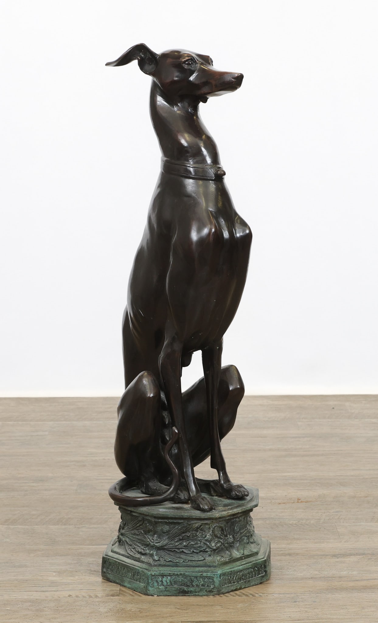 Bronze Whippet Sculpture: Bronze sculpture, depicting a seated female whippet on a columnar base. No markings noted. 33"h