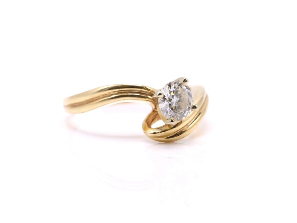 14k YG Diamond Ring: 14K yellow gold bypass style solitaire ring set with one round brilliant cut diamond weighing approximately 0.75 carat in a four prong setting. 2.8 dwt.