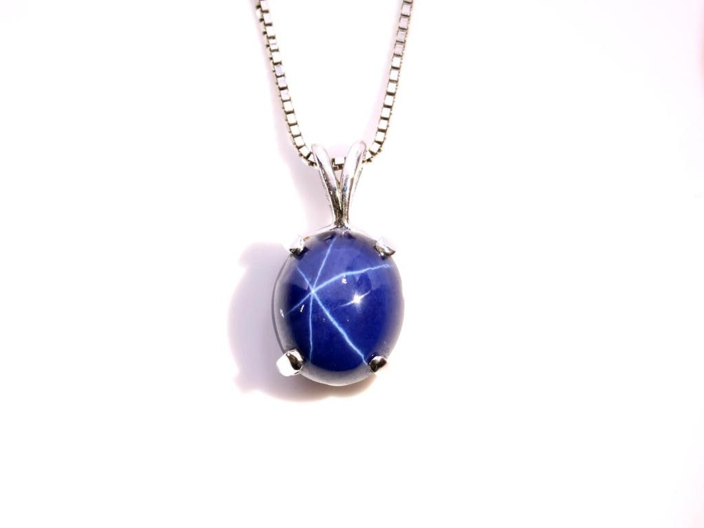 14k WG Star Sapphire Pendant: 14K white gold pendant set with an oval cabochon star sapphire suspended from a 14K white gold box link chain. Pendant 0.75", chain 14.5", combined weight 4.6 dwt.