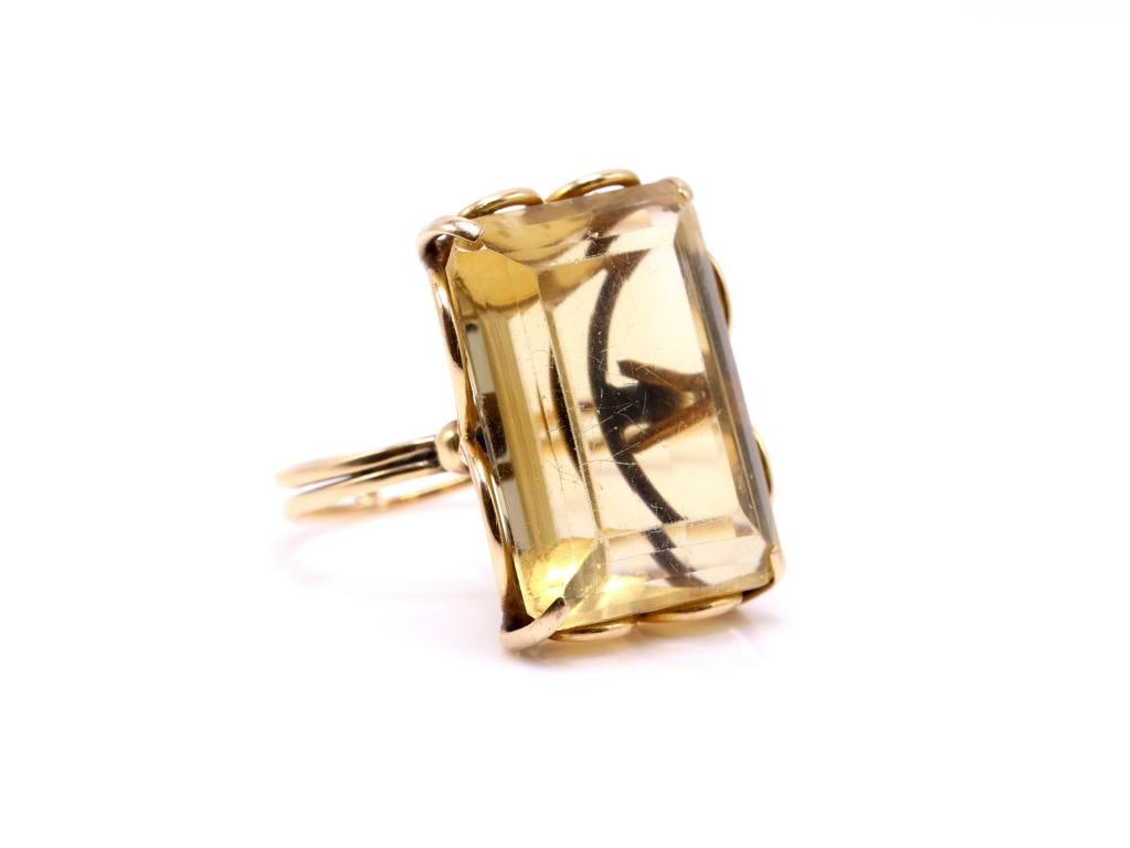 18k YG Citrine Ring: 18K yellow gold ring set with an emerald cut citrine weighing approximately 27.00 carats. Size 6.5. Total weight 7.3 dwt.