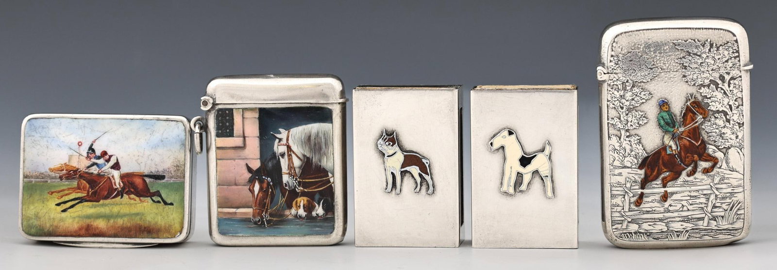 Enameled Sterling Silver Match Holders: Silver match safes with enameled horse and dog decoration. A French example with a rider jumping a fence, on a chased background, by Narcisse Salmon. A British example depicting a horse race, London, 
