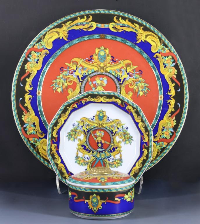 Rosenthal - Versace "Le Roi Soleil" Porcelain Tablewares: Designer porcelain pieces decorated with Louis XIV motifs, including a charger, bread & butter plate, and a covered box featuring a personified sun mask in relief. (3) pieces. Charger 12.25"w, plate