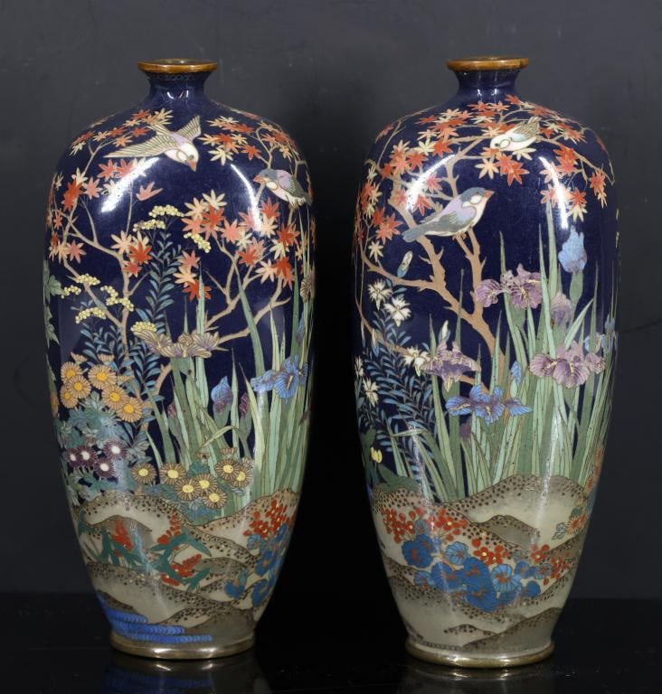 Japanese Cloisonne Vases: Meiji - Taisho pair of silver wire cloisonne hexagonal vases decorated with sparrows in a garden of various types of flowers and foliage by a stream, featuring a fish roe border around the mouth, on a