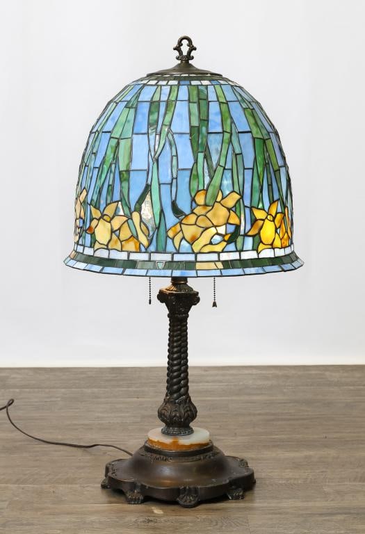 Leaded Slag Glass Table Lamp: Floral and foliate leaded slag glass umbrella shade with a corinthian foliate and bulbous stem, on an onyx and white metal scalloped base. 34"h Overall, 15"h x 18"w (shade)