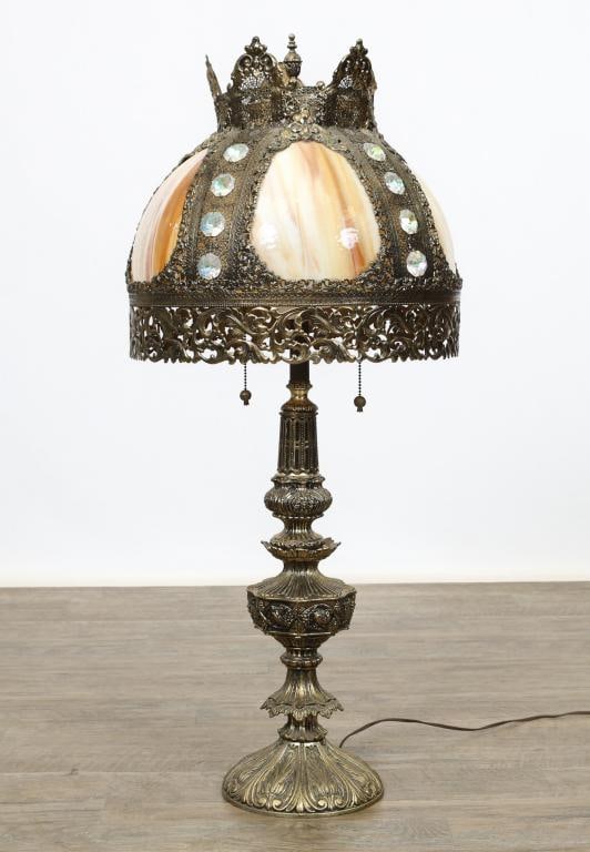 Brass and Jeweled Slag Glass Table Lamp: Brass crown form top with web style scrolled and jeweled decoration cover with frieze over a slag glass shade with a turned stem and base having fruit and foliate motifs. Overall 39"h, shade 15.5"h x 