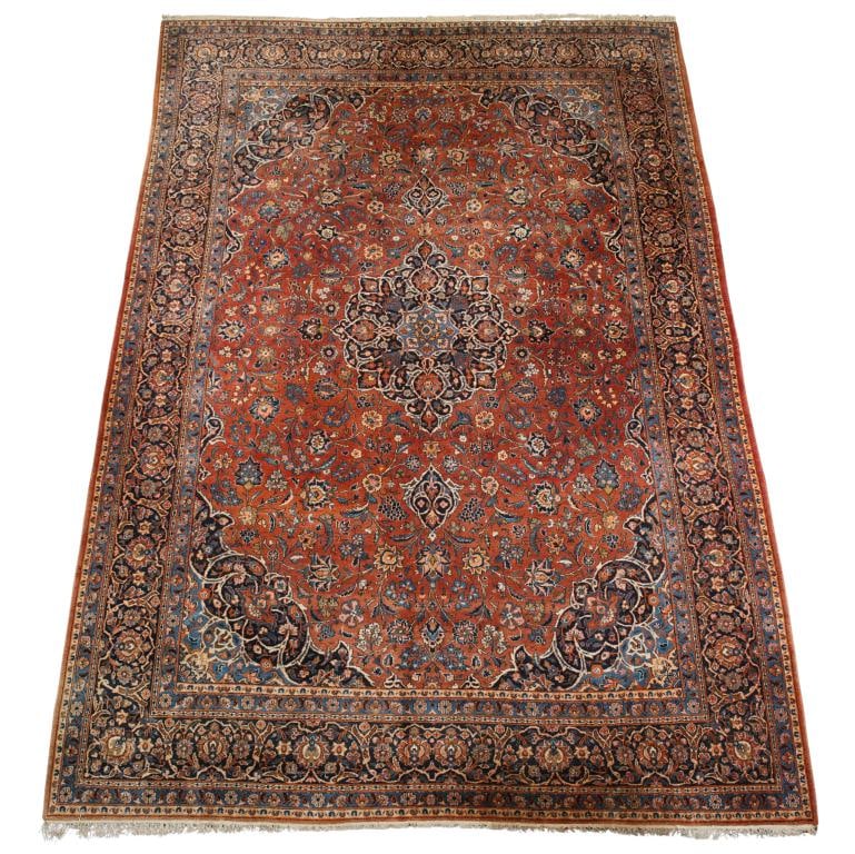 Persian Sarouk Feraghan Carpet: Hand knotted with a central cloud collar floral pendant medallion with a all over herati pattern field, vine scroll spandrels, and meandering palmette cartouches in the main border in polychrome color