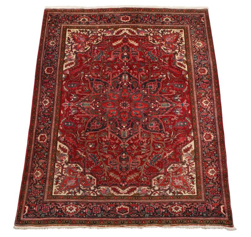 Persian Heriz Carpet: Hand knotted having an eight lobe triple central pendant medallion in a foliate and floral field with meandering stylized flowerhead cartouches in the main border in polychrome colors of red, blue, cr