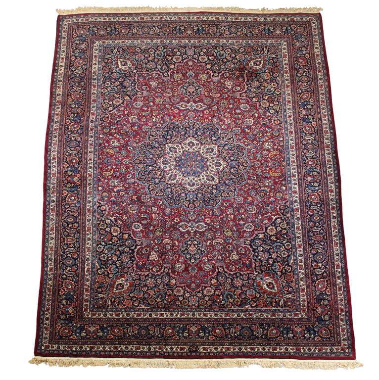 Signed Persian Tabriz Carpet: Hand knotted having a triple cloud collar stylized flowerhead and vine central medallion surrounded by a palmette, leaf and vine scroll pattern in the field, palmette corner resolution cartouches in t