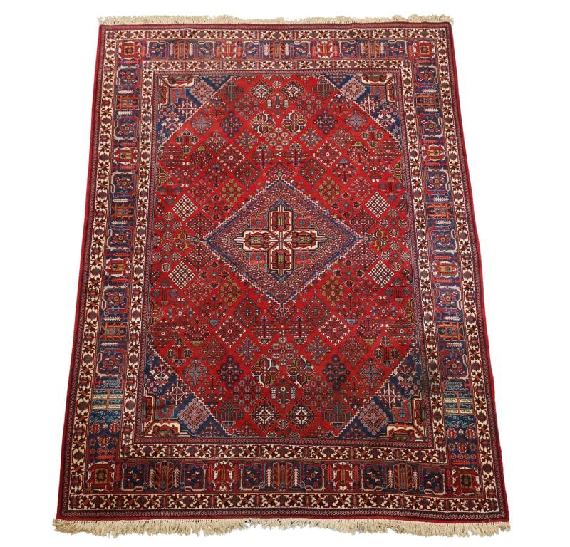 Persian Joshaqan Rug: Hand knotted with a four lobe arabesque diamond serrated central medallion with all over stylized flowerhead diamond lozenges in a red ground, serrated spandrels, repeating crab motifs in the inner an