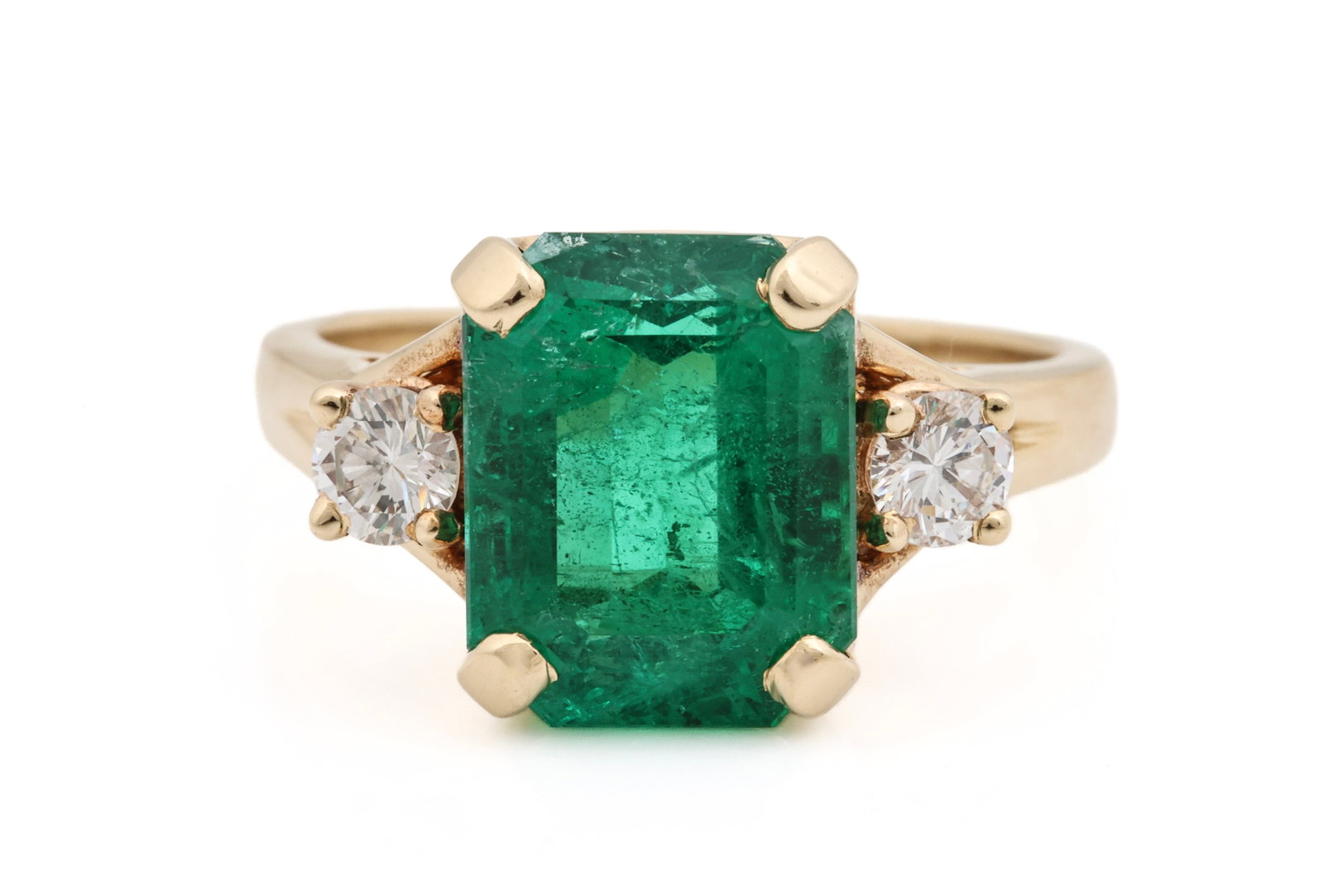 14K YG Emerald & Diamond Ring: 14K yellow gold ring with an approx. 5.20 carat emerald cut emerald flanked by (2) approx. 0.20 carat round brilliant cut diamonds. Emerald has a hairline on the table. Size 8.25 and 4.1 dwt.