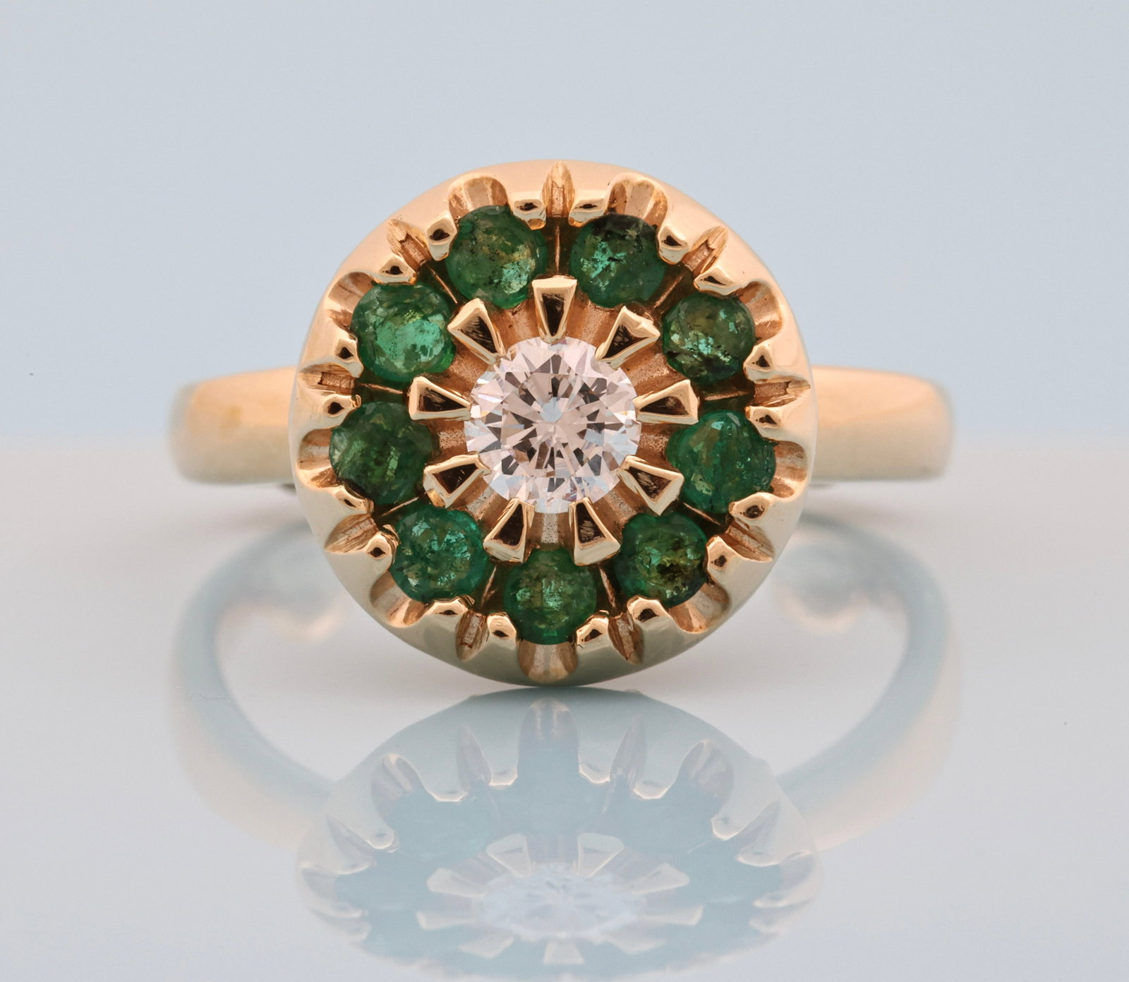 14K YG Emerald Diamond Ring: 14K yellow gold ring with approx. 0.25 carat round brilliant cut diamond center stone surrounded by round cut emeralds. Size 3.75 with sizing spacers and 3.7 dwt.