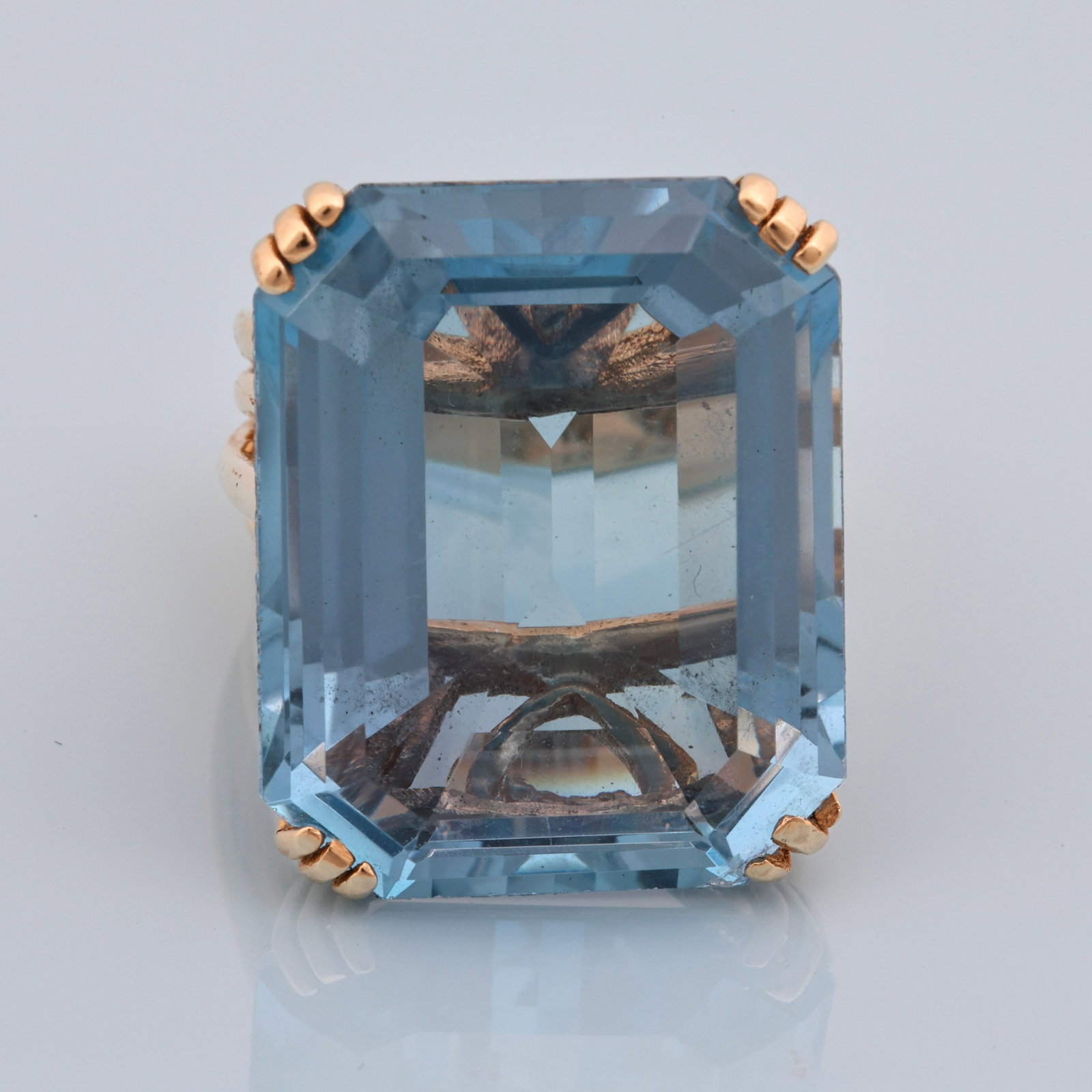 14K YG 48ct. Swiss Blue Topaz Ring: 14K yellow gold ring with a 48.00 ct emerald cut Swiss blue topaz in a split shank setting. Size 7.5. 11.1 dwt.