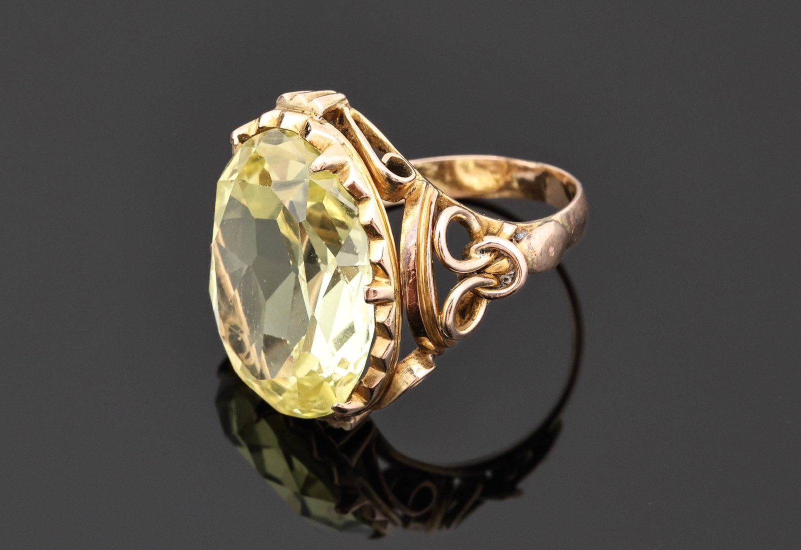 14k YG Yellow Sapphire Ring: 14k yellow gold ring set with a synthetic oval cut yellow sapphire weighing approximately 15.0 carats. Size 5.25 and 4.1dwt.