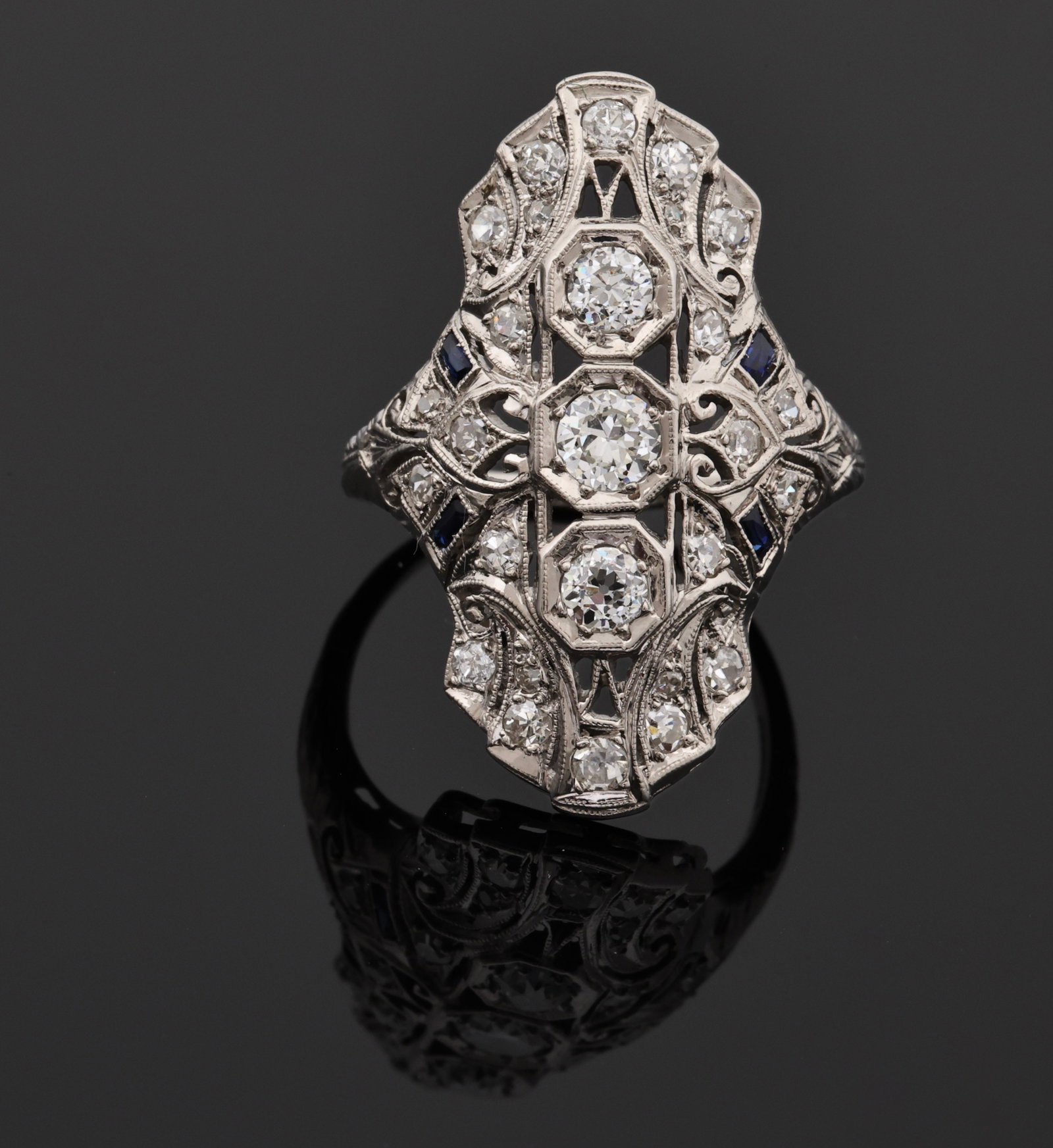 Platinum Diamond and Sapphire Ring: Art Deco platinum openwork ring with approx. 1.00 ctw old European and single cut diamonds and calibre cut sapphire accents, with engraved and milgrain details. Size 7.5 and 4.1 dwt.