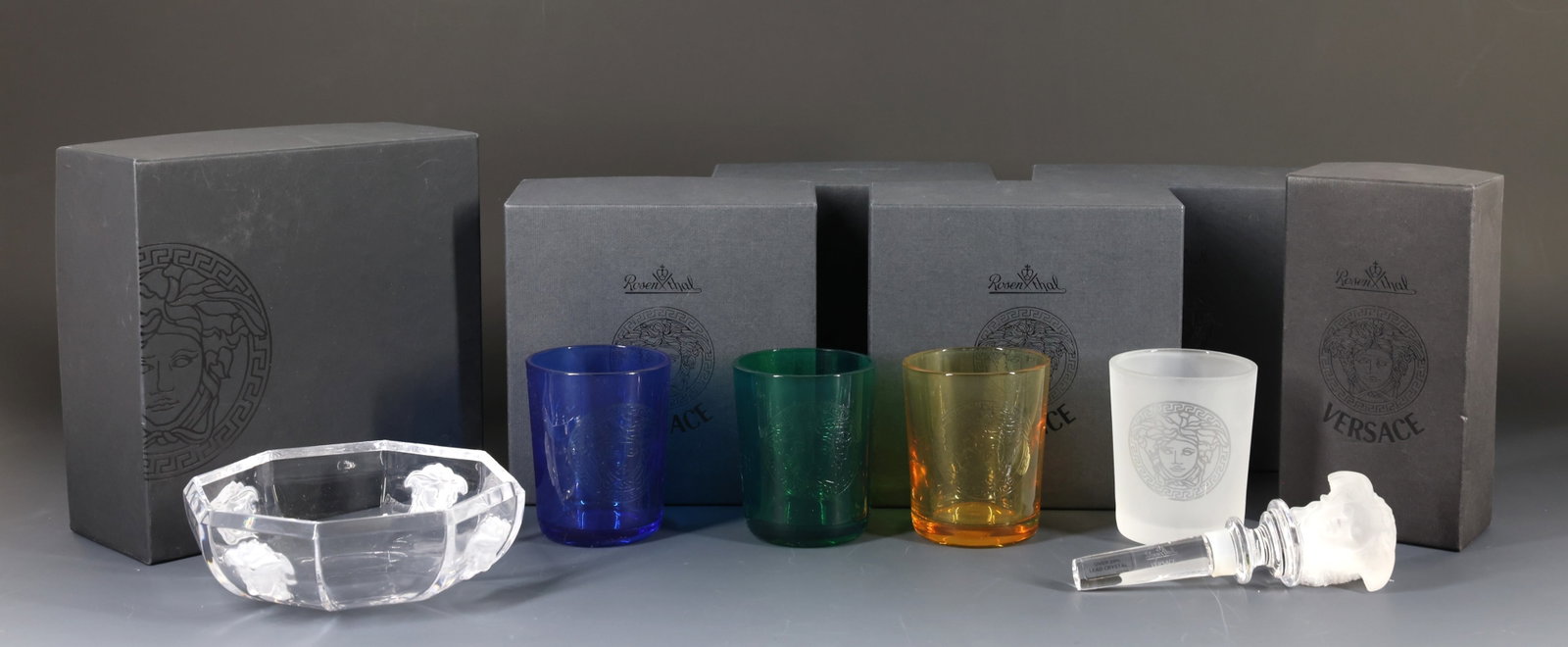 Rosenthal - Versace "Medusa Lumiere" Crystal Tablewares: Crystal tablewares, including a clear octagonal bowl and a bottle stopper decorated with frosted Medusa masks in relief, and frosted, amber, cobalt blue, and green candle votives decorated with etched