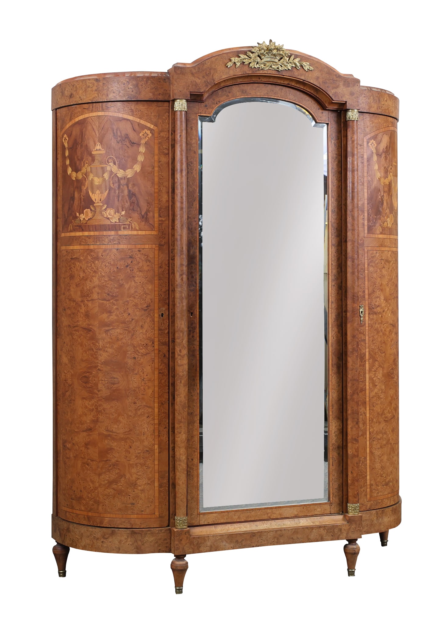 French Armoire: Black Walnut and elm burl wood case having a molded arched cornice with an ormolu mounted flower basket and foliate centerpiece, arch beveled glass door flanked by mounted capital columns and two