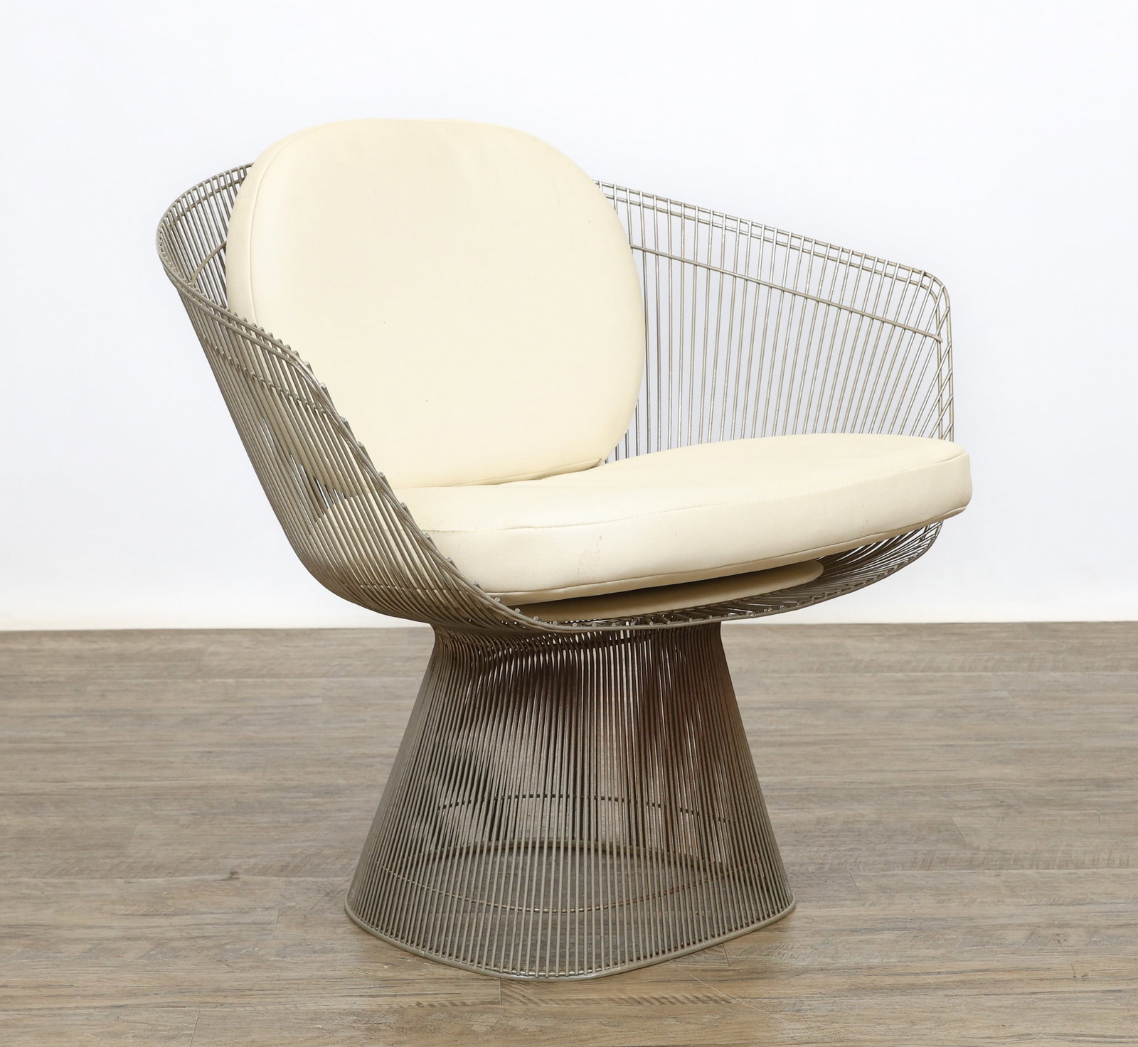 Warren Platner for Knoll Armchair: Steel wire armchair with a clear plastic gasket floor protector and removable white leather seat and back cushions supported by a removable seat support. Areas of rusting noted. 30"h x 35.5"w x 24"d,
