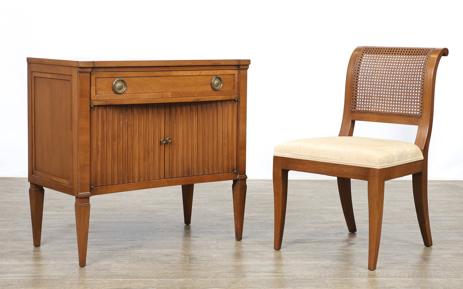 John Stuart / Mount Airy "Contessa Collection" Vanity and Chair: Directoire style vanity table in a Corinthian walnut finish with speckling and crossbanding, featuring a drawer with a fold-out mirror, over two fluted doors which open to storage space, with brass pu