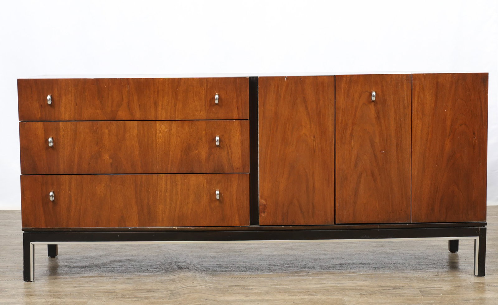 American of Martinsville Low Dresser: Walnut dresser no. 2265-215, with three graduated drawers beside two doors, one being a bifold, which open to three ebonized graduated pull-outs, all raised on a stand with straight square legs, and