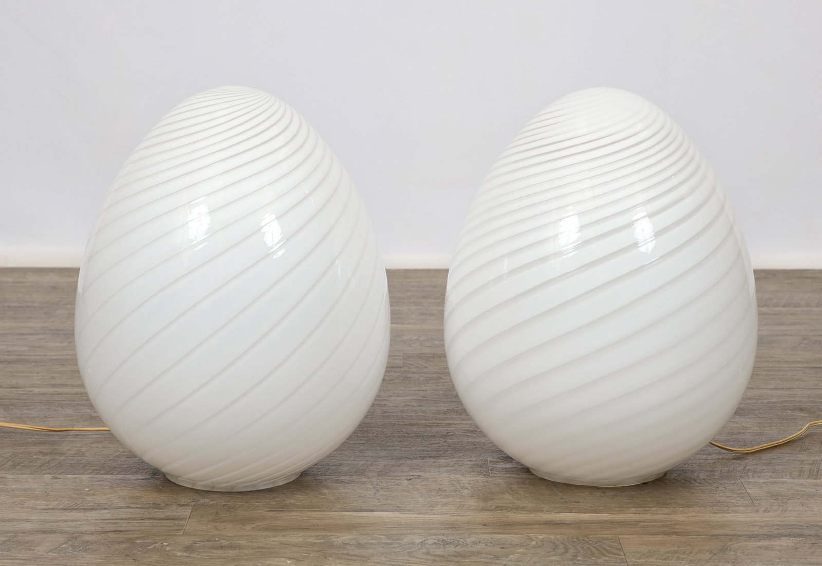Murano Glass Egg Lamps: Italian blown glass pair of egg lamps with alabastro and clear glass filigrana twist decoration. In working condition. 18"h x 13"w