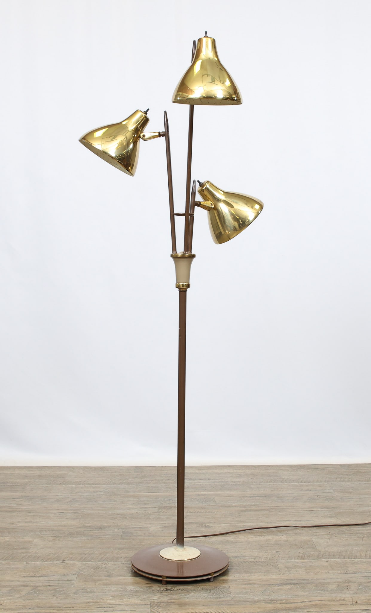 Three-Light Floor Lamp: Floor lamp with three adjustable lights, steel with brown and white enameling and brass finished accents. Part of the base has been repainted; other surface wear including pitting. In working