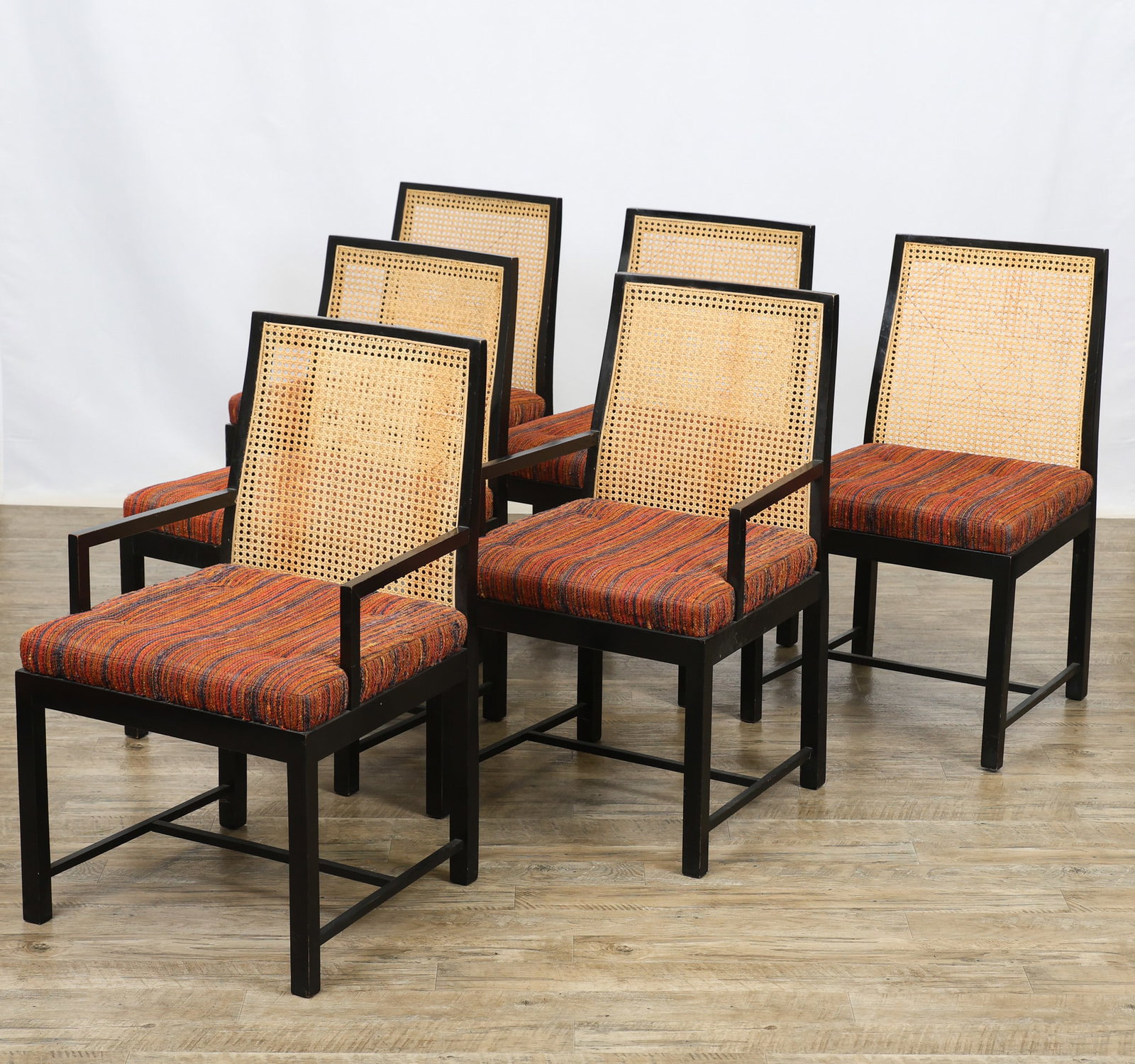 Cane Back Dining Chairs: Dining chairs with an ebonized finish and angular frames, including (2) armchairs and (4) side chairs, featuring slightly tapered and curved cane backs, tufted and textured polychrome upholstered