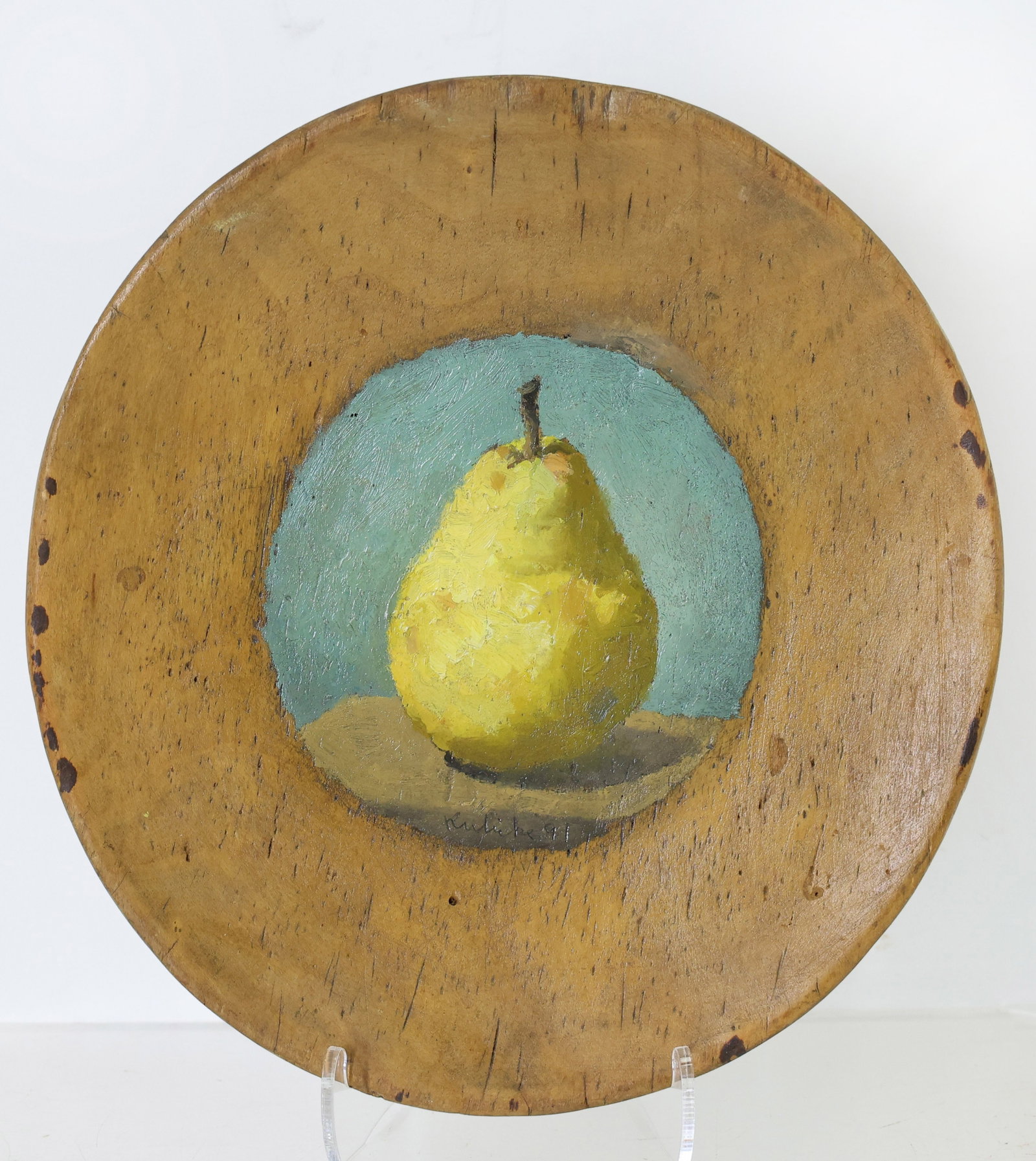 Robert Moore Kulicke (1924 - 2007): Oil on turned wood plate, SDLC, 1991. Still life with a single yellow pear against a blue green ground. 9"w.