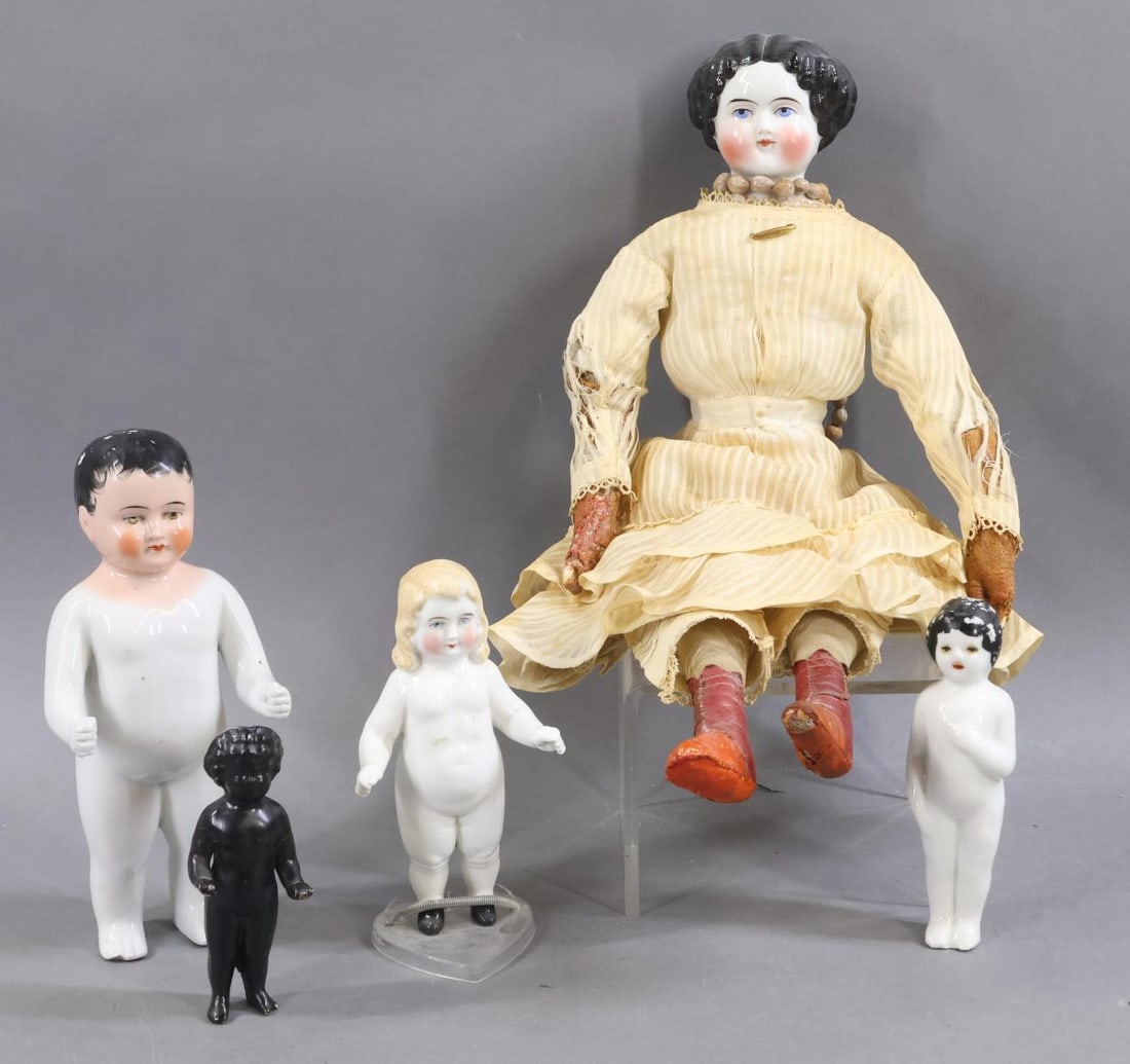 CHINA DOLLS.: LOT. (4) China "Frozen Charlotte"/Bathing dolls. 5" Has painted black hair. 5 1/2" Has painted long blonde hair and a slit in her head. Painted black shoes. 7 1/2" Has a painted head with black hair.