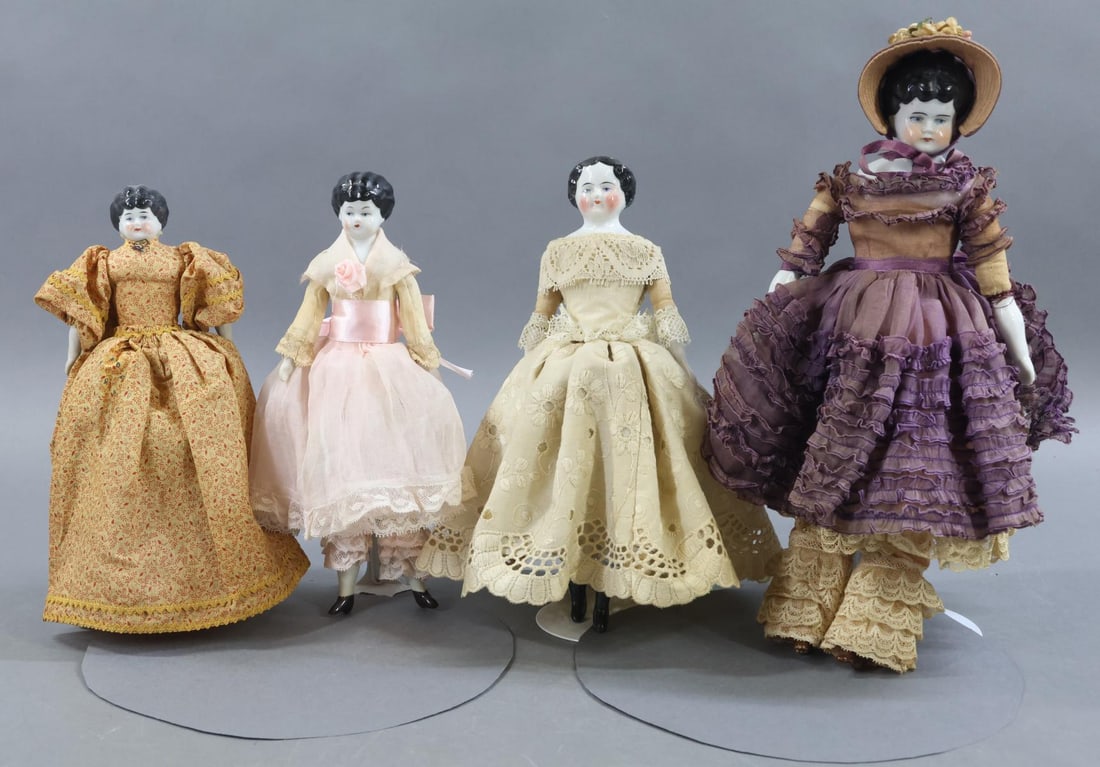 CHINA DOLLS.: LOT of (4) dolls. All of them have black hair, blue eyes. They have cloth bodies, china lower limbs, painted boots. Dressed in vintage/antique cotton clothing. (3) Stands. (3) Low Brow dolls - 8