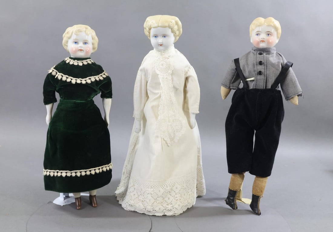 CHINA DOLLS.: LOT of (3) dolls. All of the dolls have 1880's blonde hair styles, blue eyes, cloth bodies. They are dressed in vintage/antique clothing. (3) Stands. Doll 1) 14" boy has short center part hair. Cloth