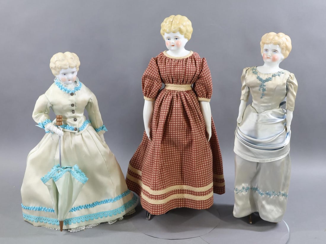 CHINA DOLLS.: LOT of (3) Low Brow dolls. All of these dolls have blonde hair, blue eyes, cloth bodies with china lower limbs. All have painted heeled boots. They are dressed in vintage clothing. (3) Stands. Doll