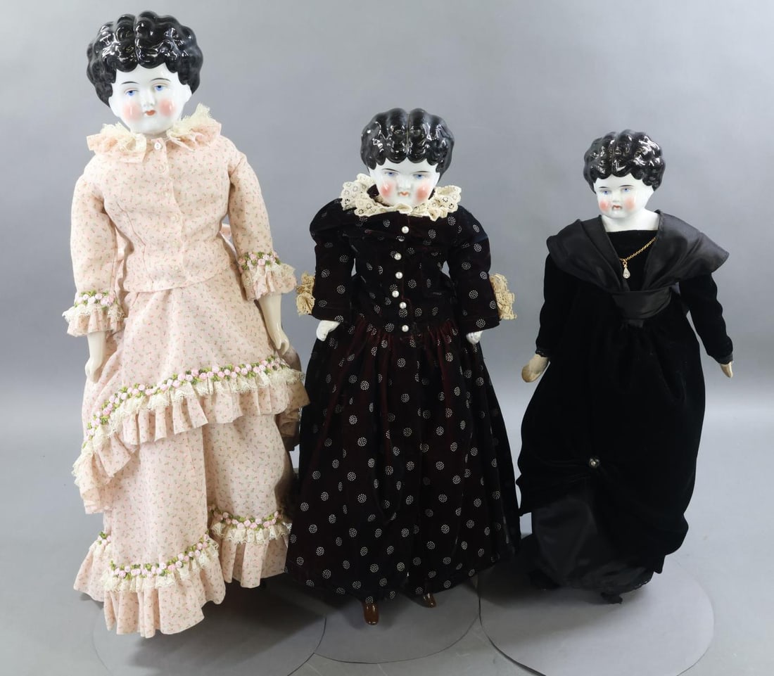 CHINA DOLLS.: LOT of (3) China Low Brow dolls. All of them have black hair, painted blue eyes. Dressed in vintage/antique clothing. Doll 1) 19 1/2" with slightly turned head. Cloth body with cloth lower limbs,