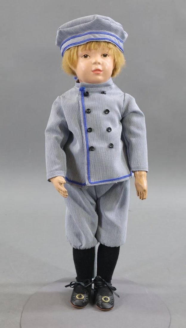 SCHOENHUT.: 16" Model No. 301/404 doll, 1911-1916. Brown intaglio eyes, replaced antique honey blonde mohair wig. Body has the incised mark on back of torso. Dressed in replaced blue cord 3 pc. outfit, black