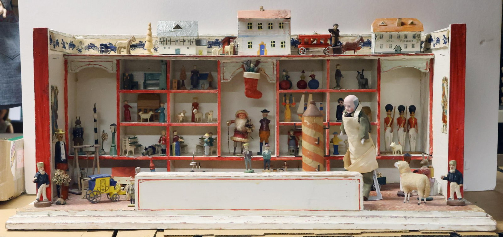 ROOM BOXES.: Antique German Wooden Toy Shop. 10 1/2" T x 10" D x 24" W. Antique wooden, papier mache items on the shelves, floor. Buildings, carts/wagons, boats, swing set, furniture. Soldiers, ladies, men. Animal