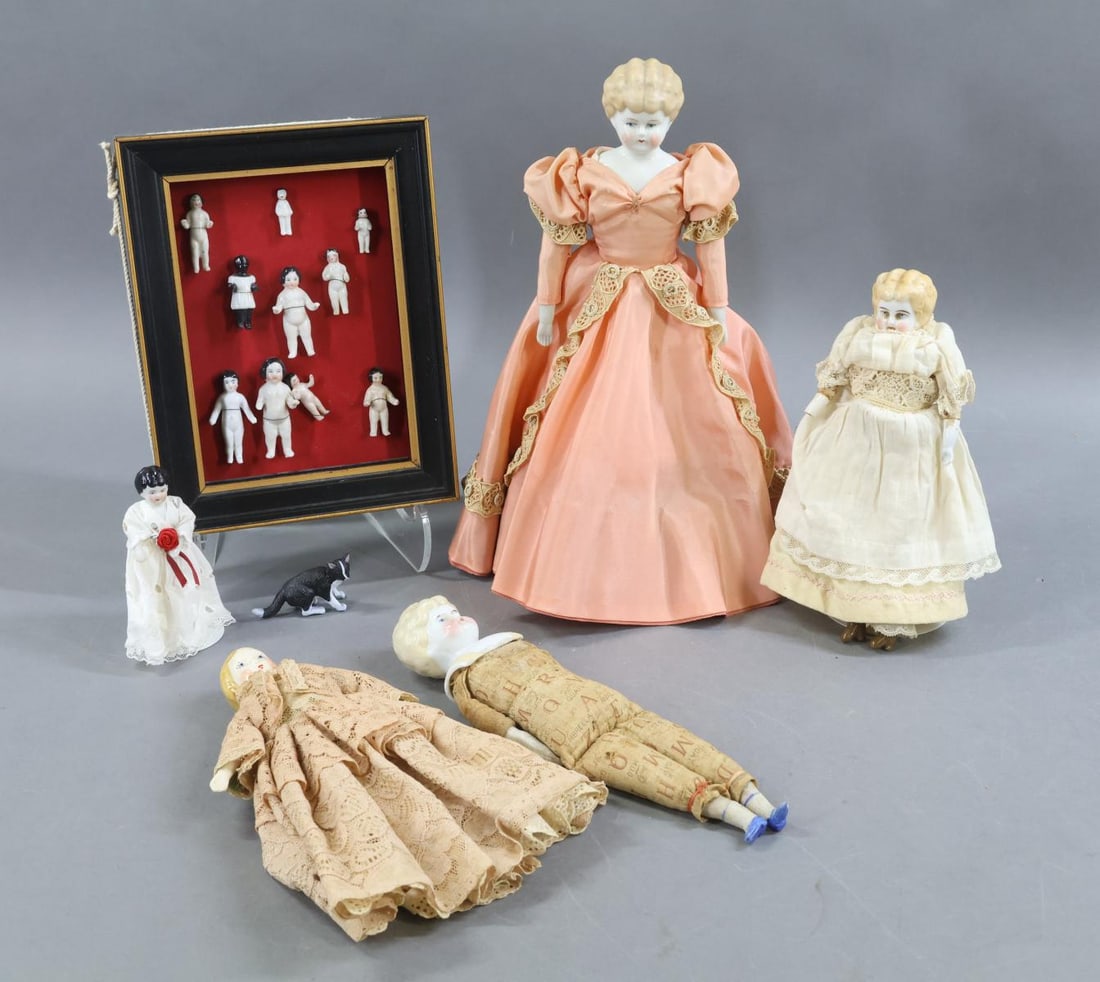 CHINA DOLLS.: LOT. (3) Blonde Lowbrow dolls - 8 1/2" (right hand missing), 9 1/2" (with printed alphabet body), 11" (fully dressed). 4" Low Brow with her (newer) kitty. (2) Stands. Condition: as stated. 7 1/2"