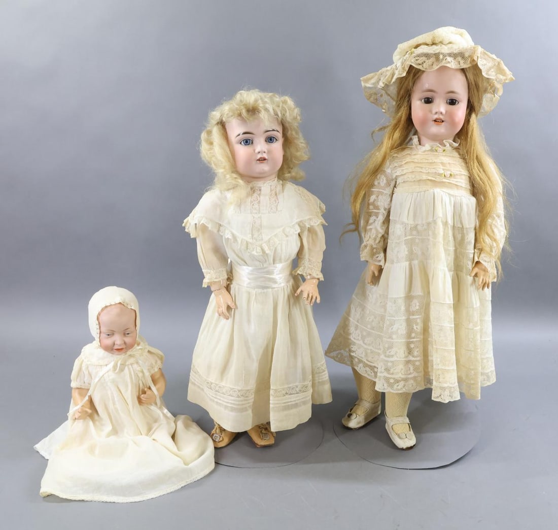GERMAN BISQUE DOLLS.: LOT of (3) dolls. All of them have papier mache bodies and are dressed in antique white cotton clothing. Doll 1) "Sister" - 20" J. MADE IN GERMANY 13 129 with blue sleep eyes, open mouth, pale blonde