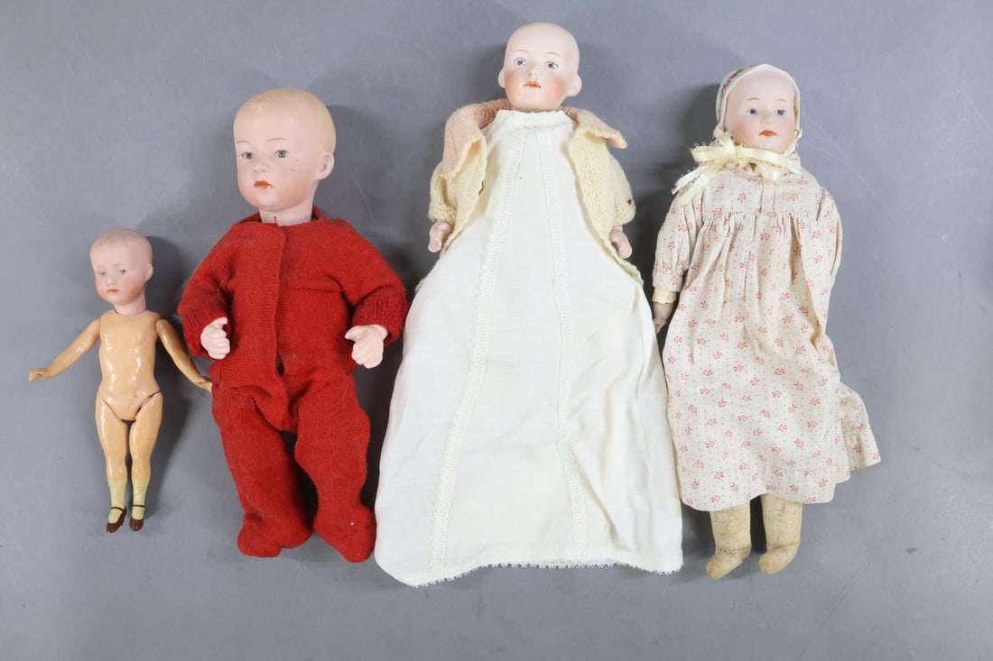 GERMAN BISQUE CHARACTER DOLLS.: LOT of (4) HEUBACH solid dome character babies. All of these dolls have painted blue intaglio eyes, closed mouths. (3) Are wearing antique clothing. 11" "Baby Stuart" 7877 or 7977 shoulder head doll