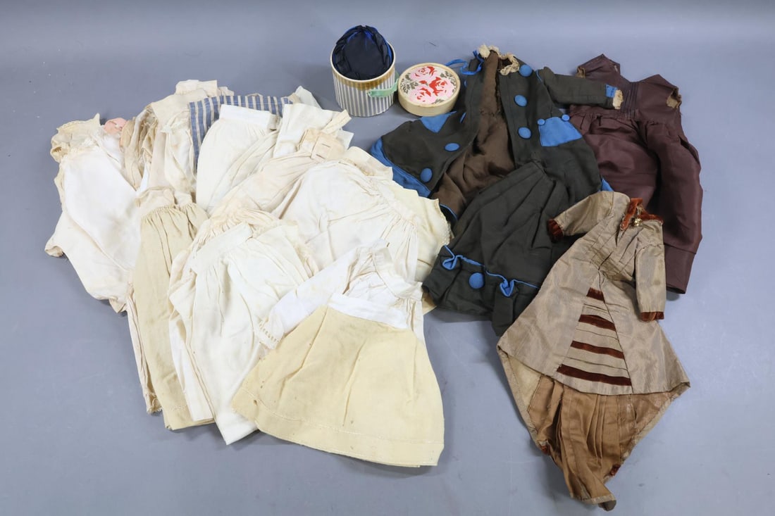 DOLL CLOTHING, ACCESSORIES.: LOT of antique clothing and accessories. Clothing - for a French Fashion doll. Silk long coat, 2 pc. fine wool long coat and skirt. Black silk hat in hat box. Other - silk dress. Cotton - stripe hat,